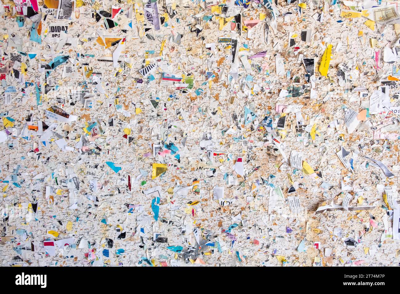 A vintage community bulletin board covered in the torn multicolored scraps of old flyers and advertisements. An abstract detail of a message board for Stock Photo