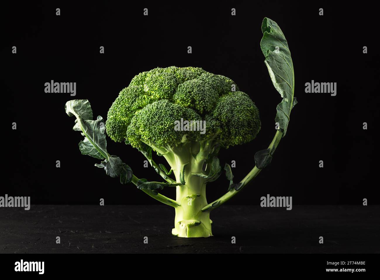 Fresh broccoli florets on black rustic background Stock Photo