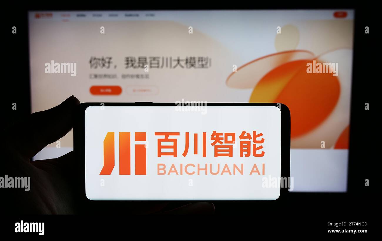 Person holding smartphone with logo of Chinese artificial intelligence company Baichuan AI in front of website. Focus on phone display. Stock Photo