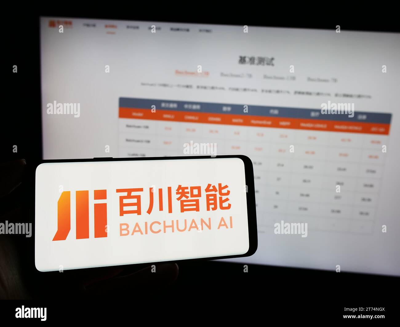 Person holding cellphone with logo of Chinese artificial intelligence company Baichuan AI in front of business webpage. Focus on phone display. Stock Photo