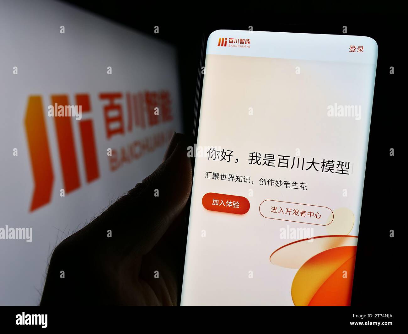 Person holding smartphone with webpage of Chinese artificial intelligence company Baichuan AI in front of logo. Focus on center of phone display. Stock Photo