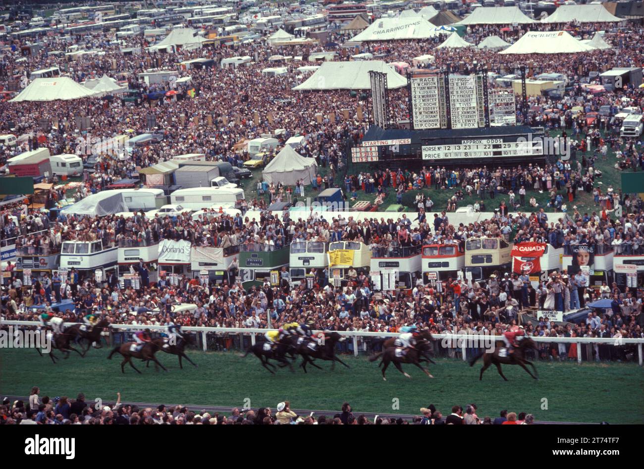Derby Day, Epsom  Downs, the Derby horse race. The horse coming into finish the crowd of spectators 'On the Hill', on the cheaper not paying stand side of the race track.  Epsom Downs, Surrey, England June 1985 1980s UK HOMER SYKES Stock Photo