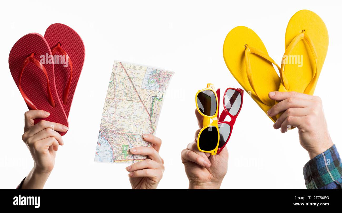 Hand holding travel items with flip flops sunglasses Stock Photo