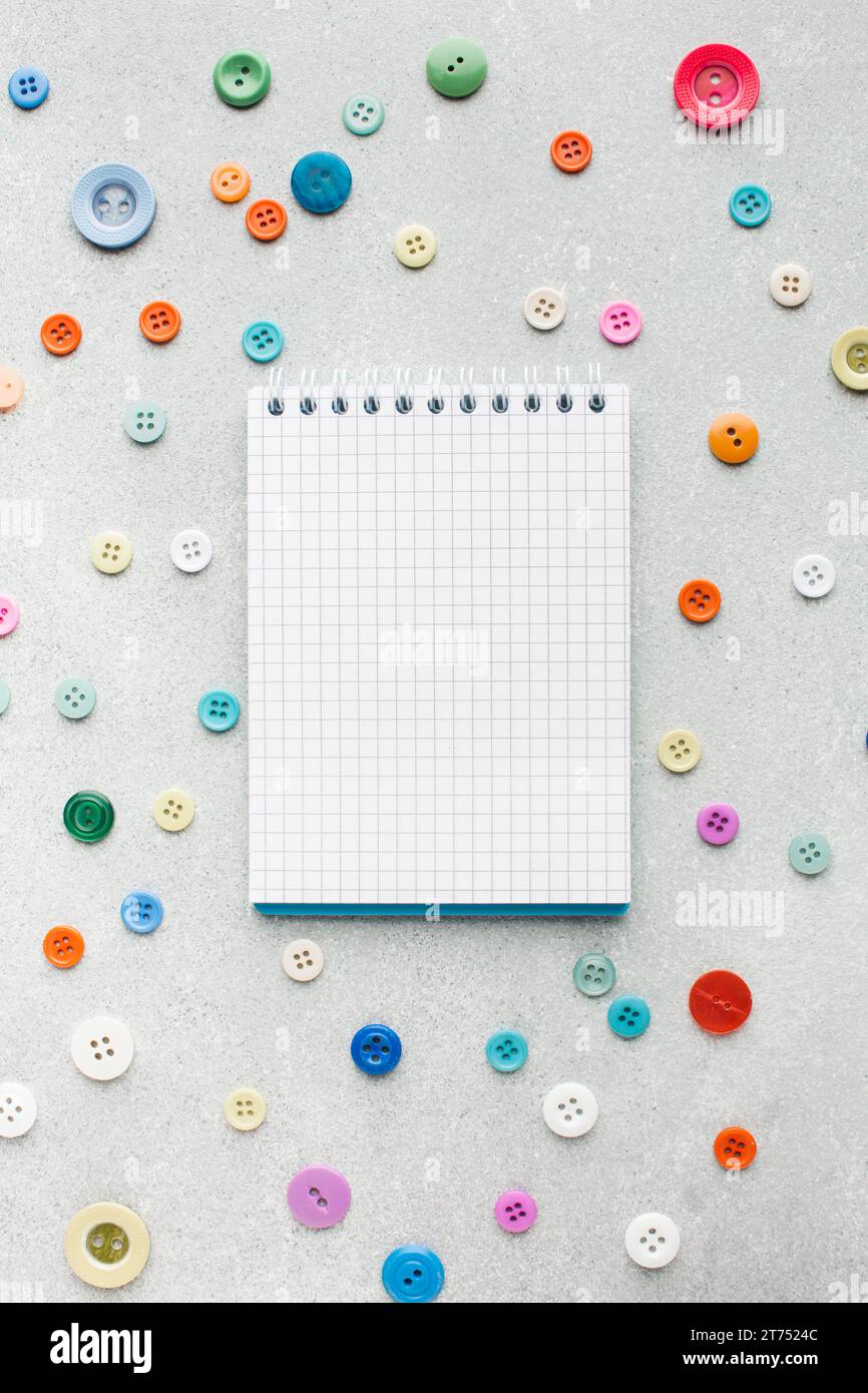 Empty notepad surrounded by colourful buttons Stock Photo