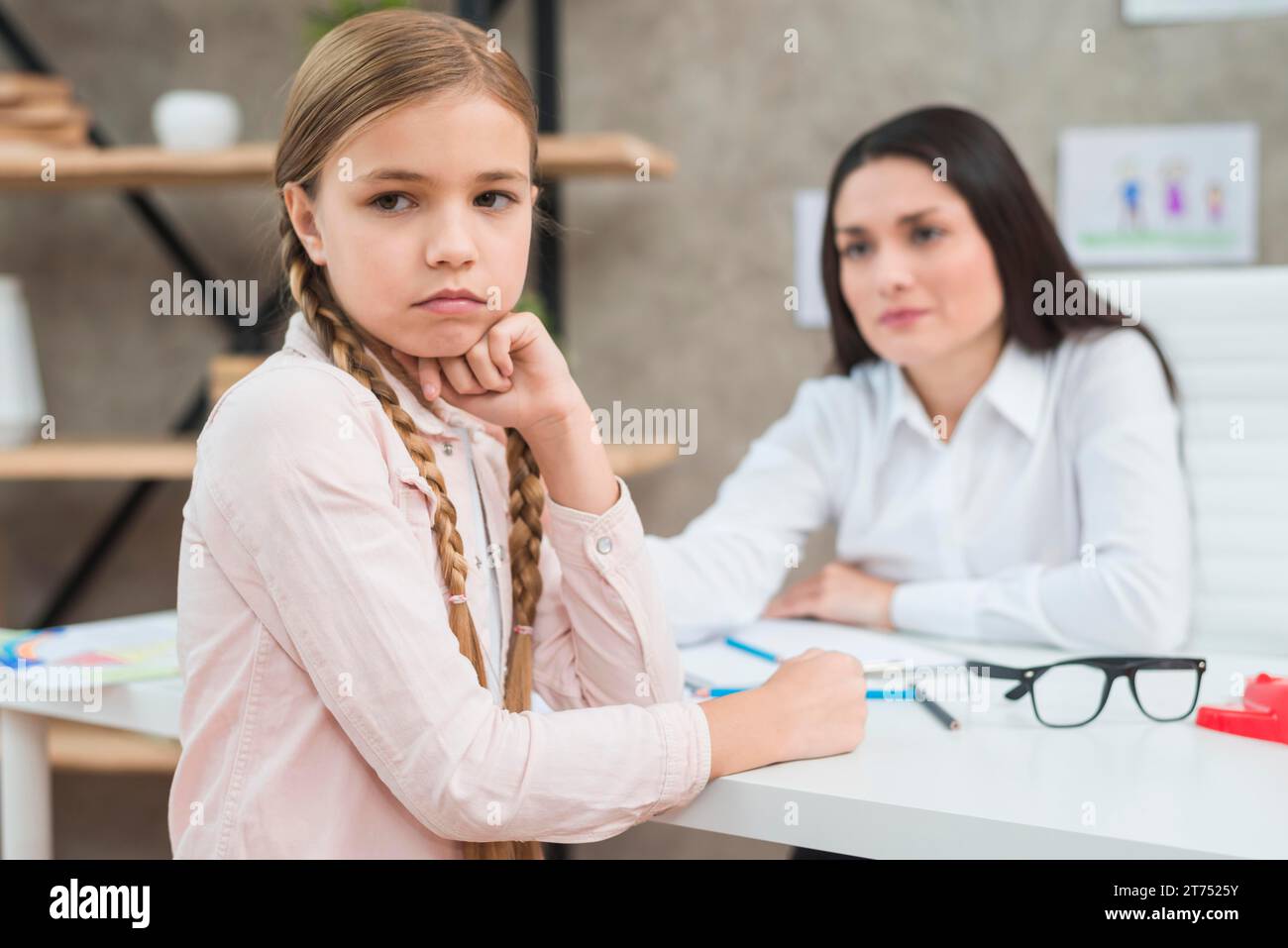 Depressed girl sitting front her female psychologist Stock Photo