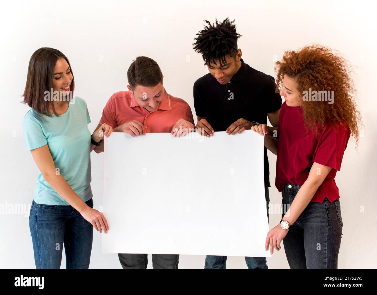 Group smiling multiethnic friends holding blank white placard standing white background Stock Photo