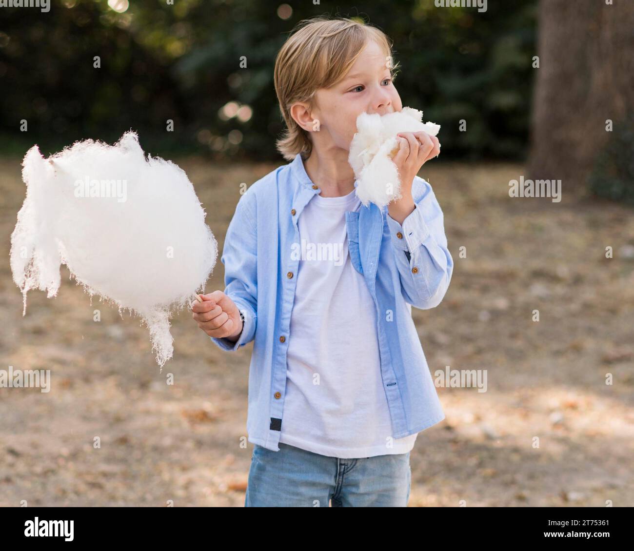 Medium shot kid eating cotton candy Stock Photo