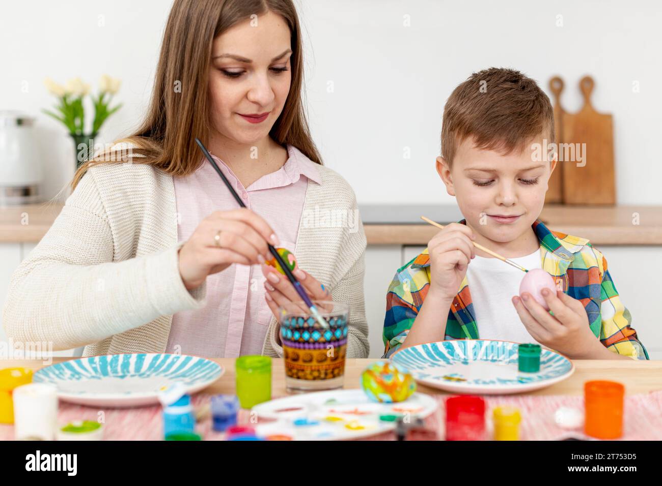 Mother son home painting eggs Stock Photo