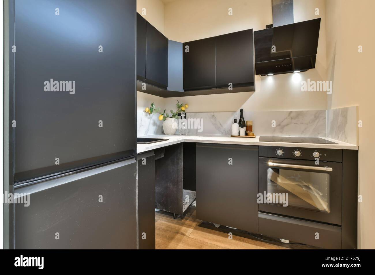 a kitchen with black cabinets and white marble counter tops on the