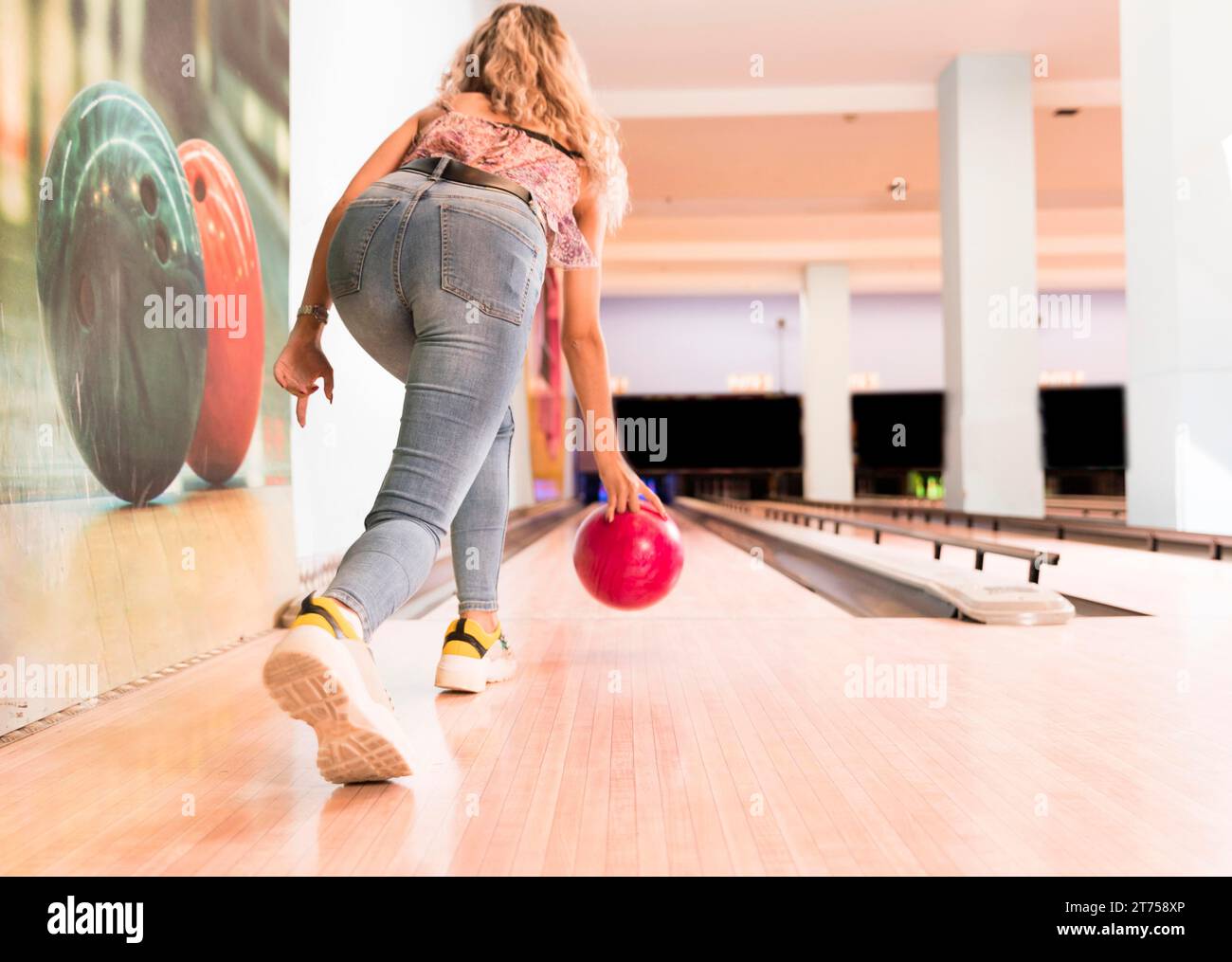 Back view woman throwing bowling ball Stock Photo