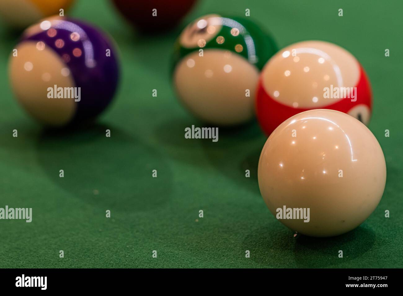 Colorful pool balls arranged on a billiard table, promising