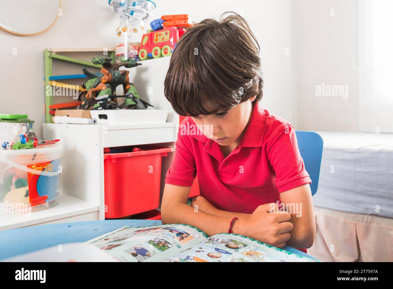 Child reading book table Stock Photo
