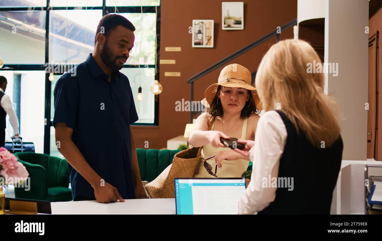 Hotel guests showing passports at front desk, using id documents for