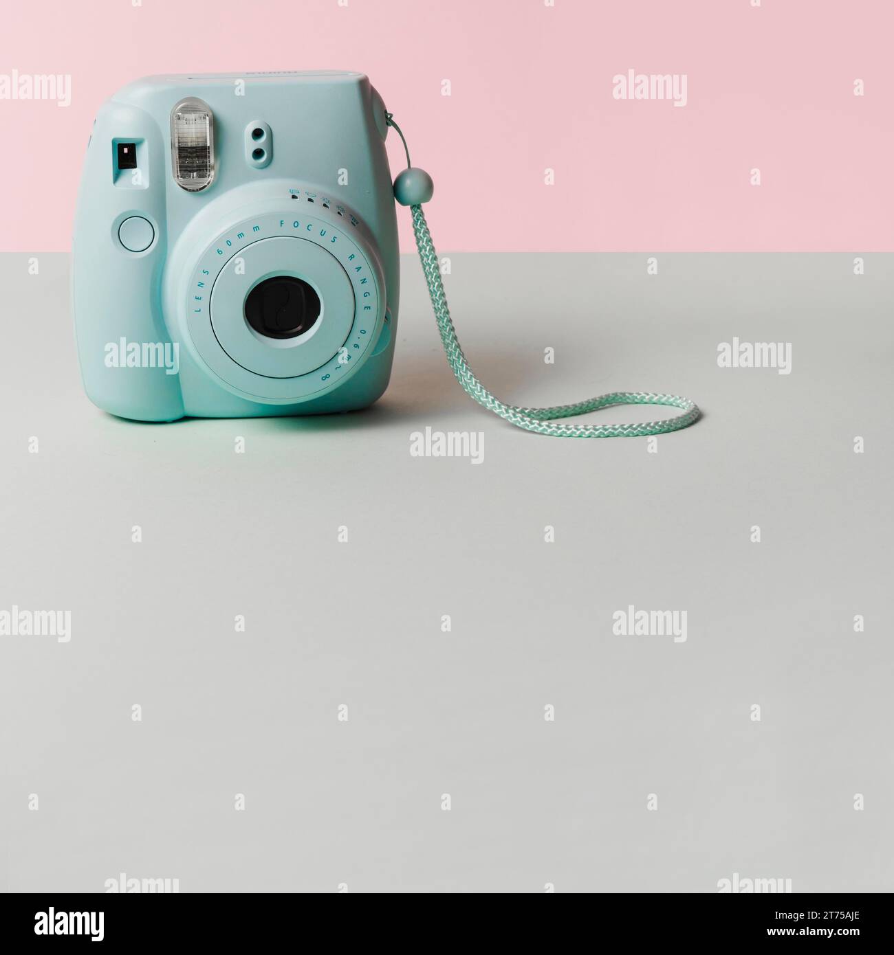 Mini blue instant camera gray desk against pink background Stock Photo