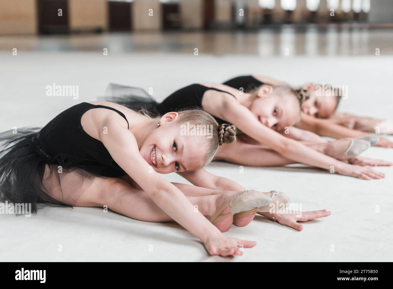 Smiling ballerina girls posing dance floor Stock Photo