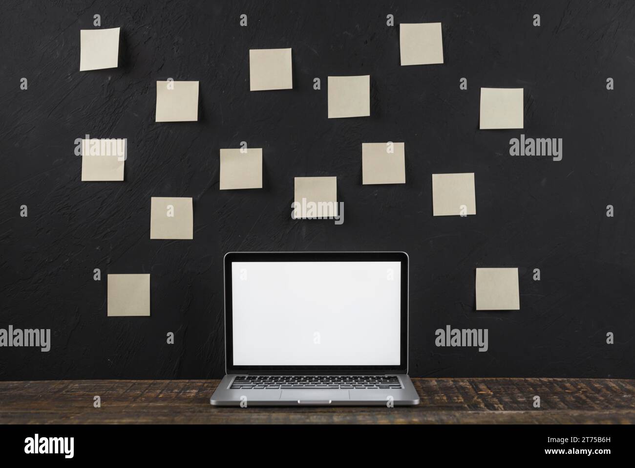 Sticky note stick black wall white blank screen laptop Stock Photo