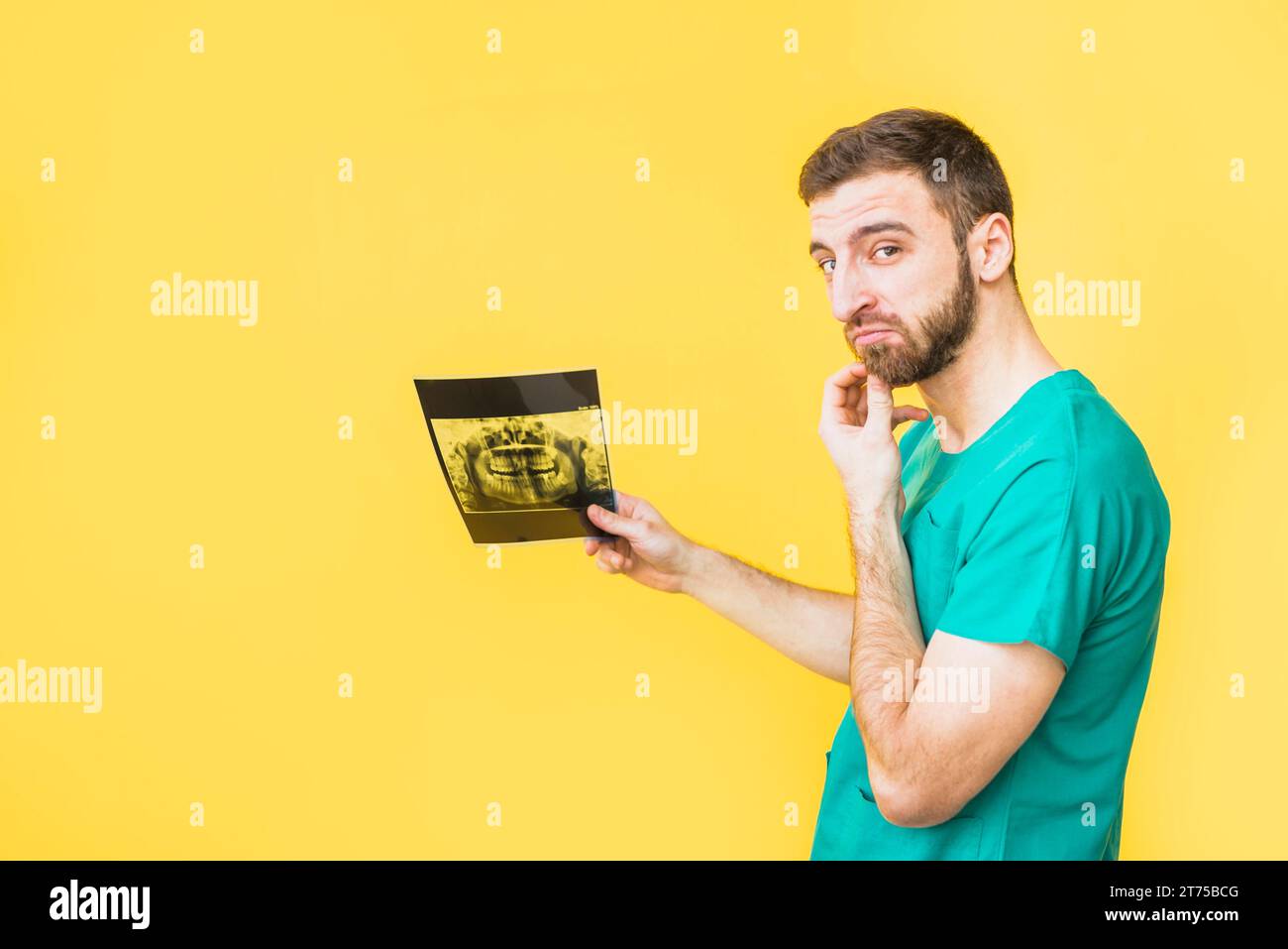 Thoughtful dentist holding teeth x ray Stock Photo