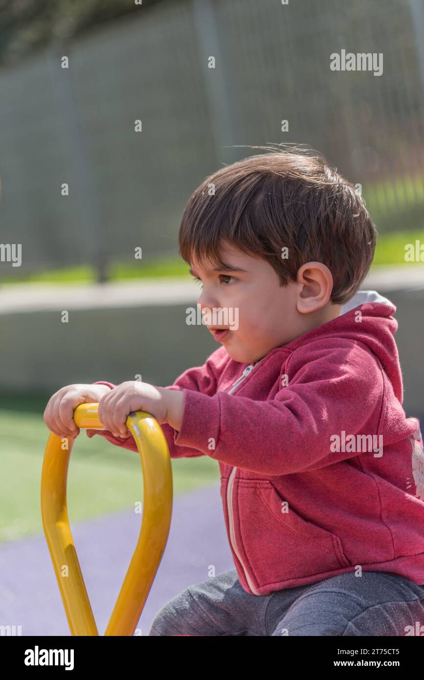 Little boy enjoying playing outdoors in the playground Stock Photo - Alamy