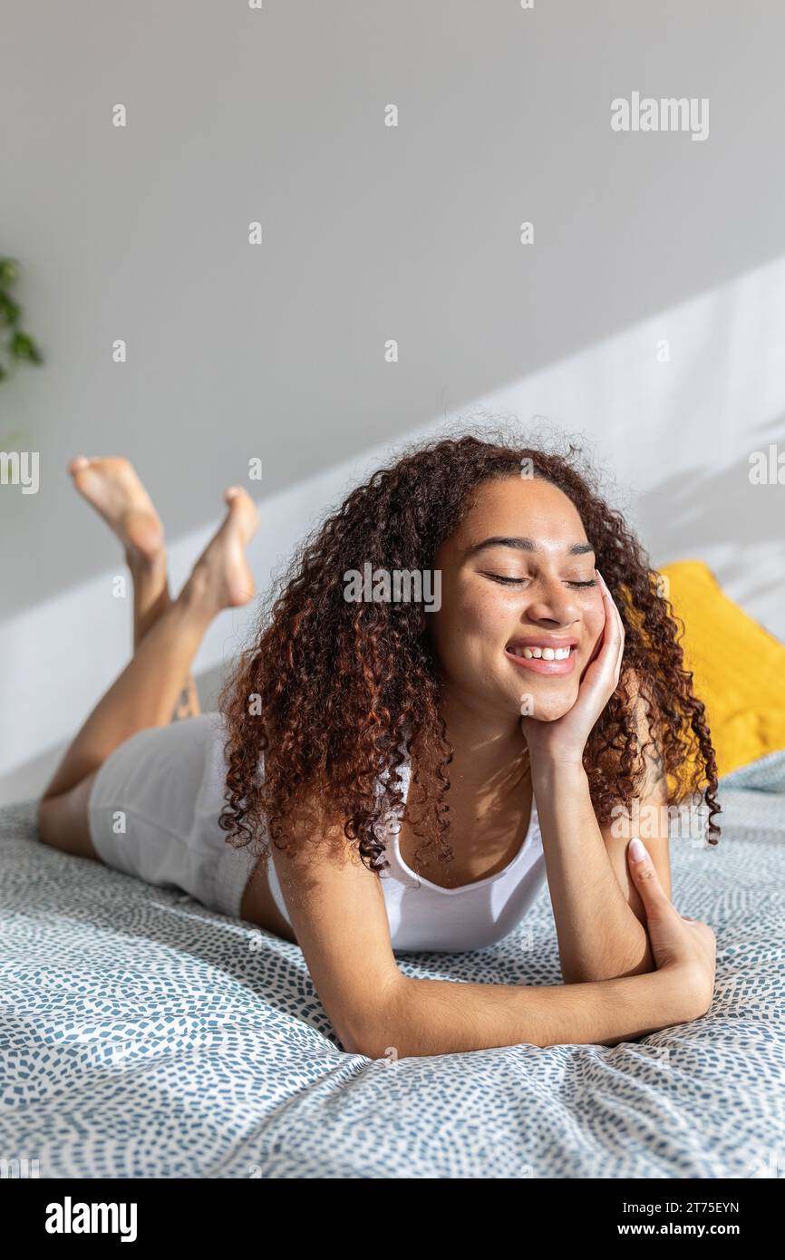 Happy young latin girl with closed eyes enjoying sunlight in the ...