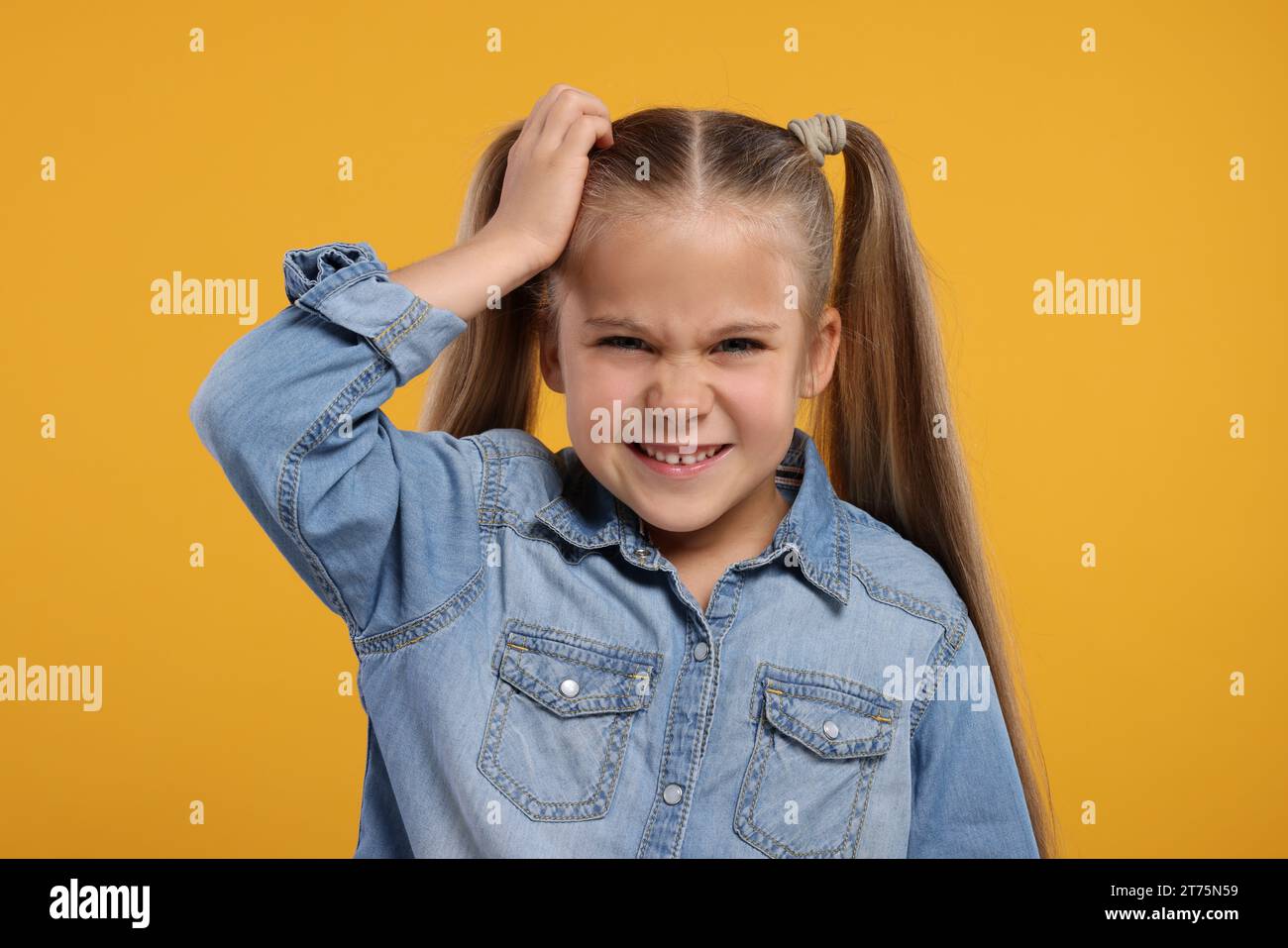 Portrait of embarrassed little girl on orange background Stock Photo - Alamy