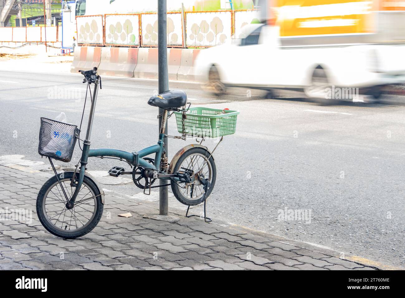The bicycle parked on a kickstand on the sidewalk next to a busy road, Bangkok, Thailand Stock Photo