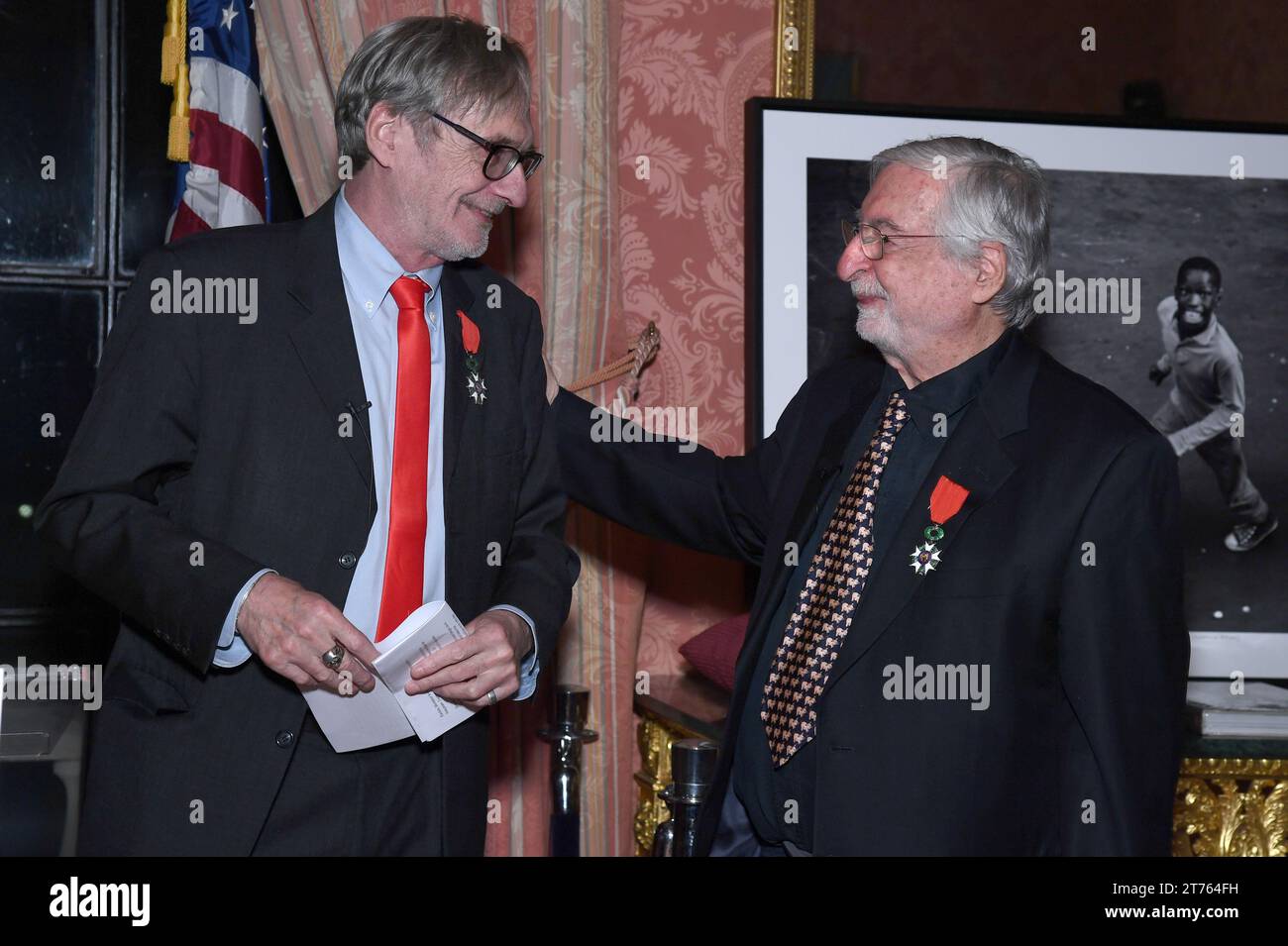 New York, USA. 13th Nov, 2023. French Photojournalist Jean-Francois Leroy (l) smiles after giving insignia of Knight in the National Order of the French Legion of Honor to French-American Photojournalist Jean-Pierre Laffont (r), ceremony held at the Consulat General de France in New York, NY, November 13, 2023. (Photo by Anthony Behar/Sipa USA) Credit: Sipa USA/Alamy Live News Stock Photo