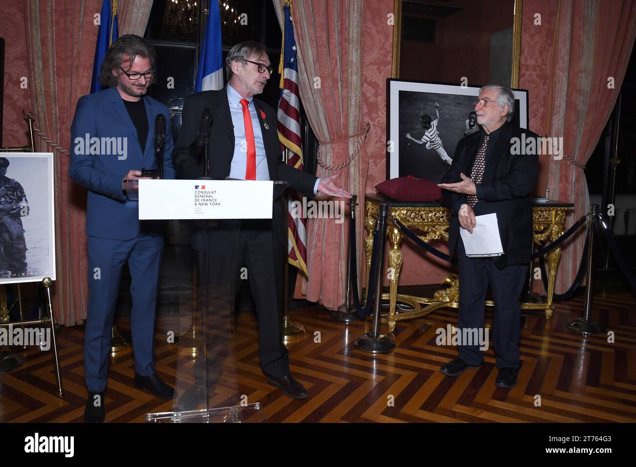 New York, USA. 13th Nov, 2023. French Photojournalist Jean-Francois Leroy (2nd left) speaks before gathered guest before presenting photojournalist Jean-Pierre Laffont (r) with the insignia of Knight in the National Order of the French Legion of Honor, at the Consulat General de France in New York, NY, November 13, 2023. (Photo by Anthony Behar/Sipa USA) Credit: Sipa USA/Alamy Live News Stock Photo