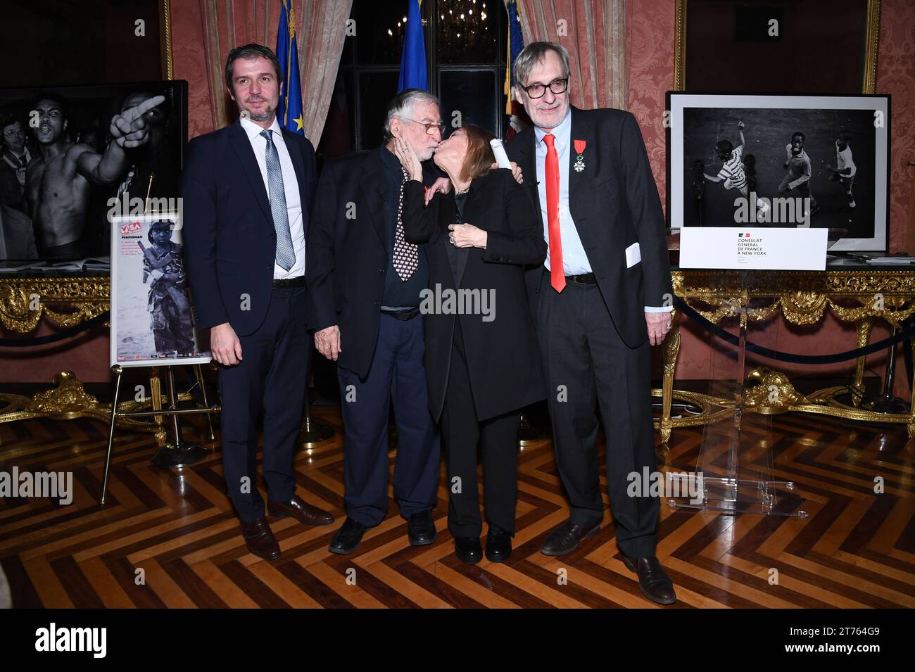 New York, USA. 13th Nov, 2023. French-American photojournalist Jean-Pierre Laffont kisses his wife Eliane Laffont as they pose with Jeremie Robert (l), Consul General of France in New York and French photojournalist Jean-Francois Leroy at after the ceremony awarding Mr. Laffont with the insignia of Knight in the National Order of the French Legion of Honor, held at the Consulat General de France in New York, NY, November 13, 2023. (Photo by Anthony Behar/Sipa USA) Credit: Sipa USA/Alamy Live News Stock Photo