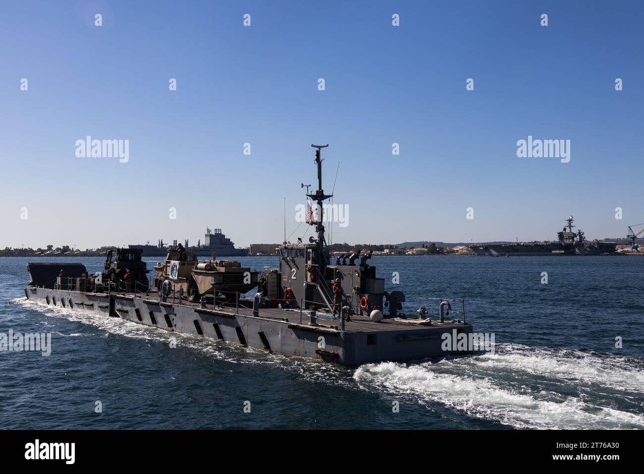 The Improved Navy Lighterage System Causeway Ferry 01 with Amphibious Construction Battalion One floats past Broadway Pier for the 4th Annual Fleet Week Veterans Day Boat Parade during Fleet Week San Diego at San Diego, Nov. 12, 2023. 48 San Diego pleasure boats participated in the parade as well as a variety of Navy boats and craft. FWSD is an opportunity for the San Diego residents and tourists to meet their Navy, Marine Corps and Coast Guard teams and experience America’s sea services. During fleet week, service members participate in various community relations events, showcase capabilitie Stock Photo