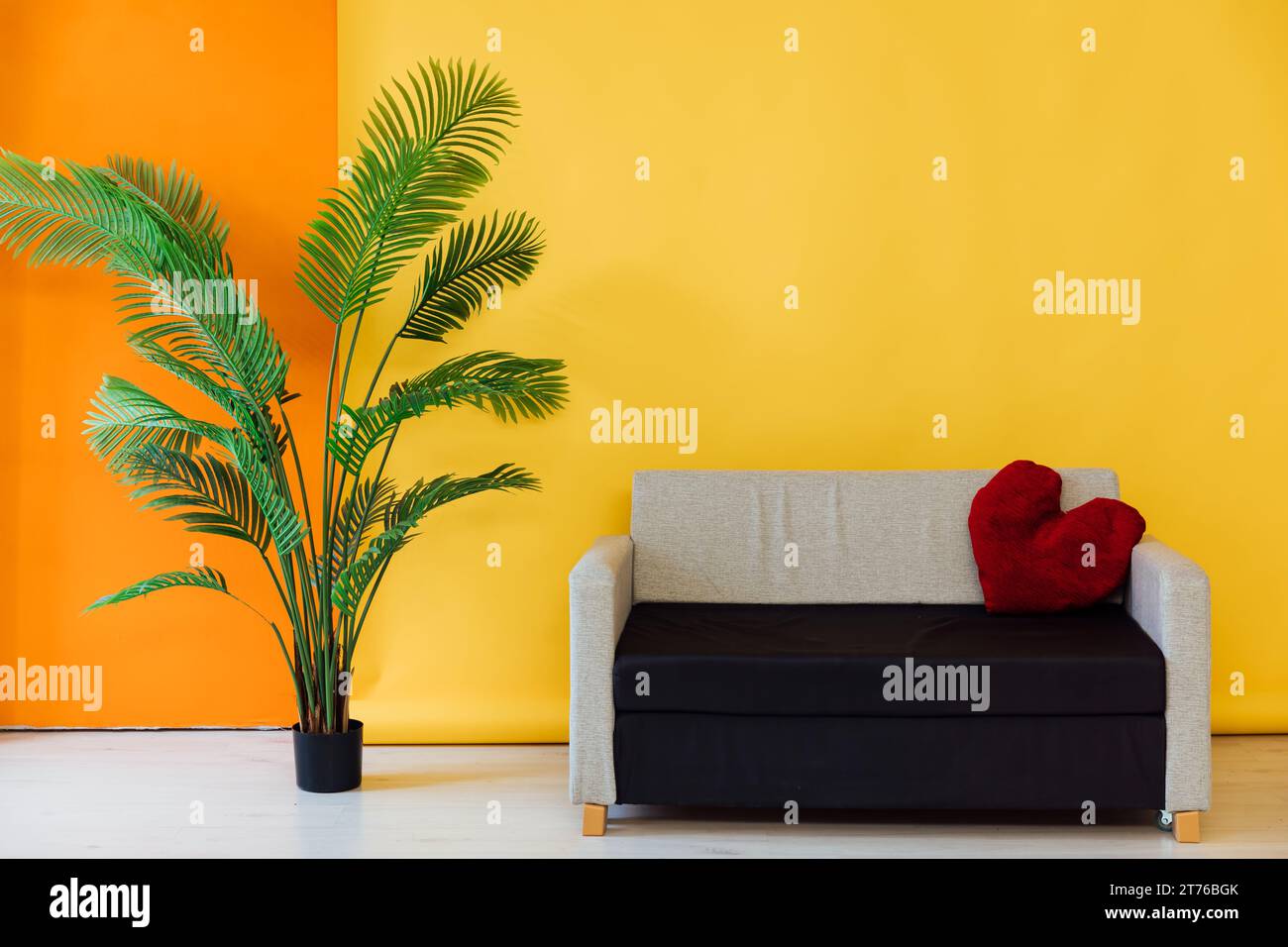 Yellow orange room interior with grey black office sofa at home Stock Photo