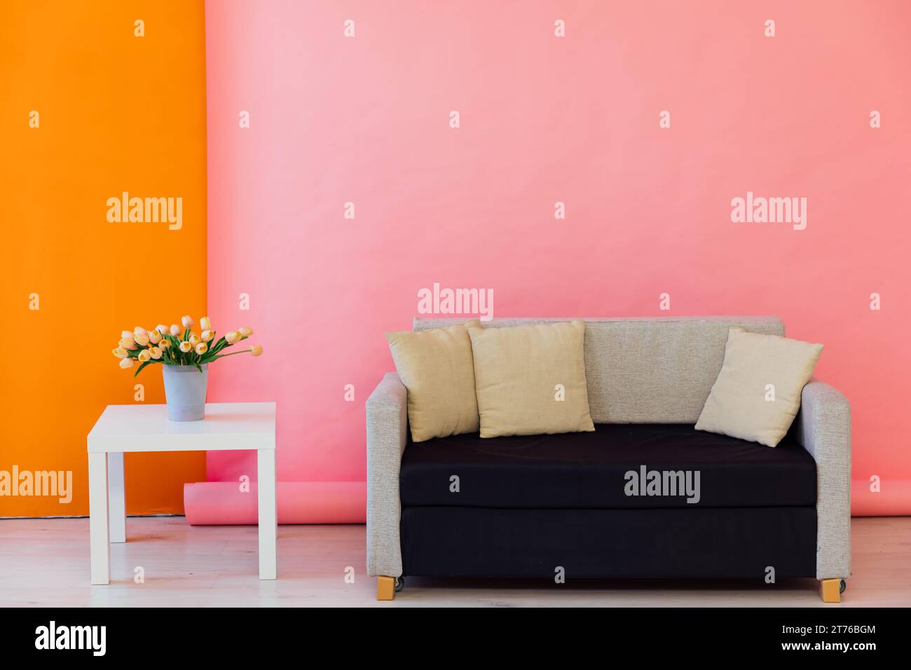 Pink orange room interior with grey office sofa and flowers Stock Photo