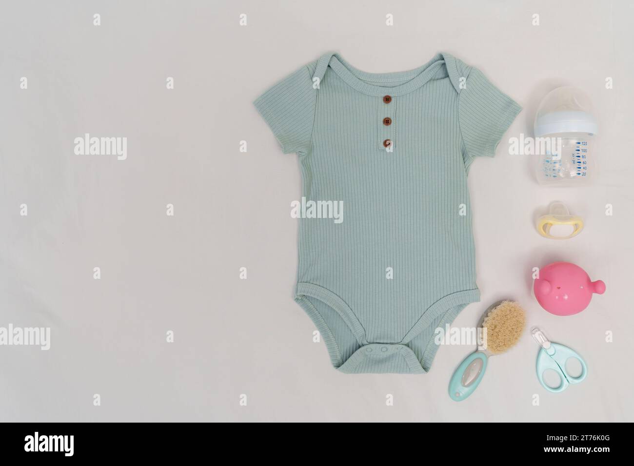 set of baby clothes and accessories on a white bed Stock Photo Alamy