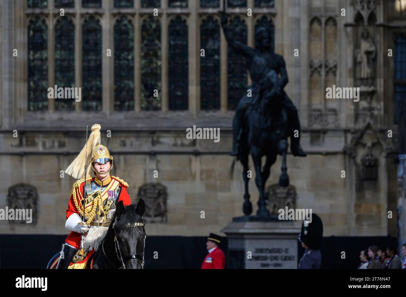 Member of the Household Cavalry riding past the statue of Richerd I in Westminster during King Charles III first State Opening of Parliament as king. Stock Photo