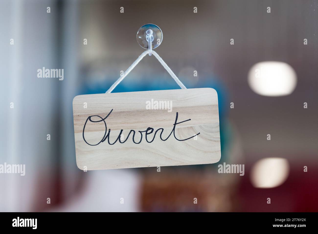 Circular blue sign in the window of a shop saying in French Magasin ouvert  à tous, meaning in english Store open to all Stock Photo - Alamy