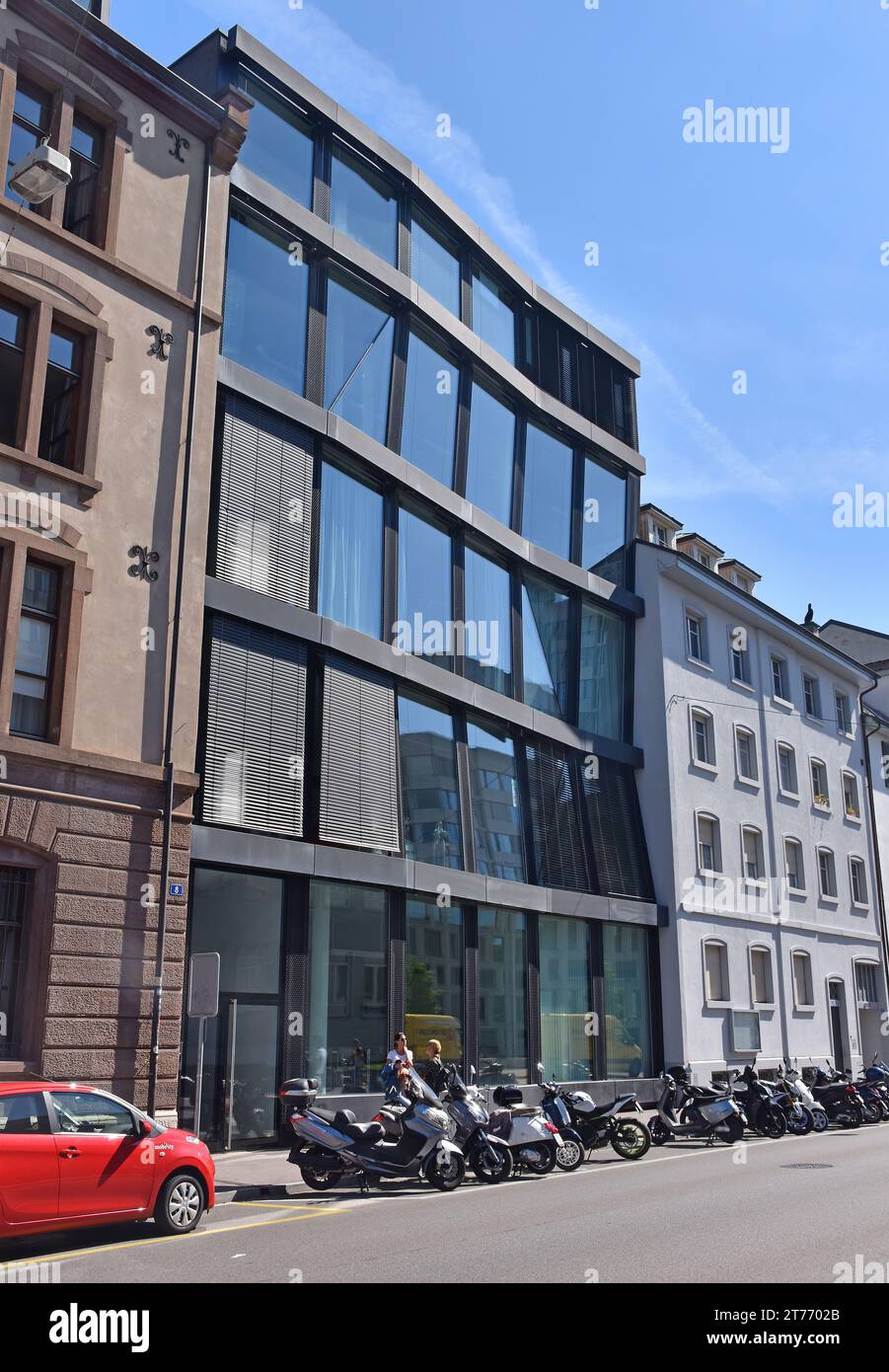 Steel-framed building, flat front, 6 bays, 5 storeys, 1 door & 29 large sheets of glass, frame is subtly distorted, in a slightly unsettling way. Stock Photo