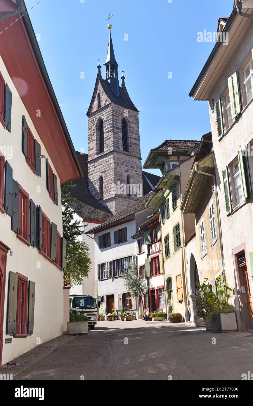 One of the many beautifully preserved historic streets in the Old Town, Altstadt Basel, Switzerland, with the tower of  Peterskirche in the background Stock Photo