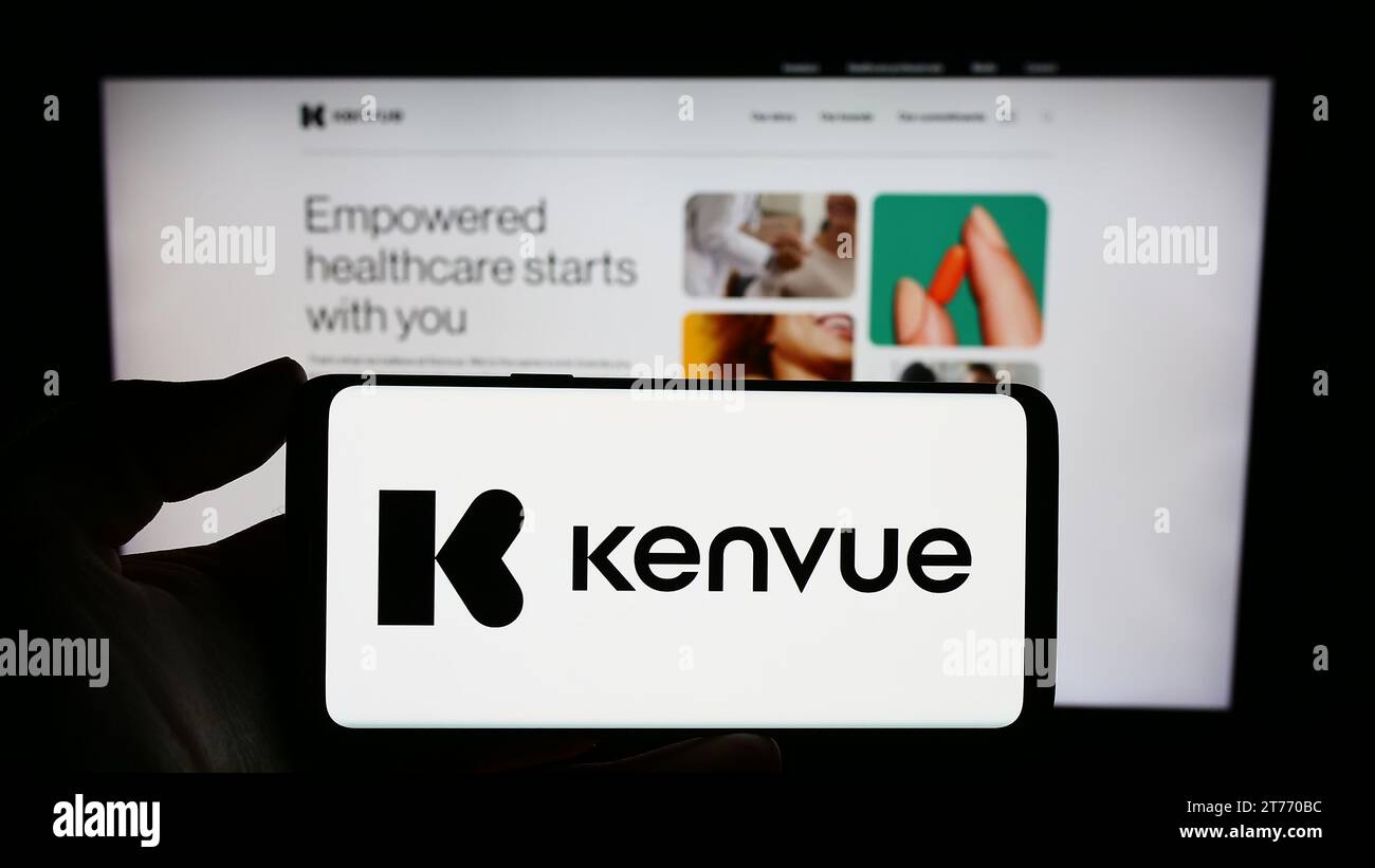 Person holding smartphone with logo of US consumer health products company Kenvue Inc. in front of website. Focus on phone display. Stock Photo