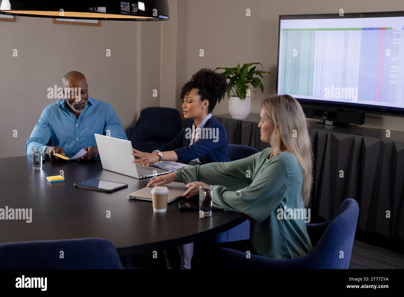 Happy diverse colleagues using laptops in meeting room Stock Photo - Alamy