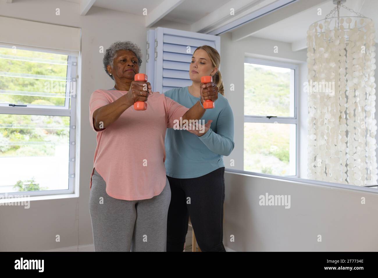 Caucasian female physiotherapist and senior afrcian american female ...