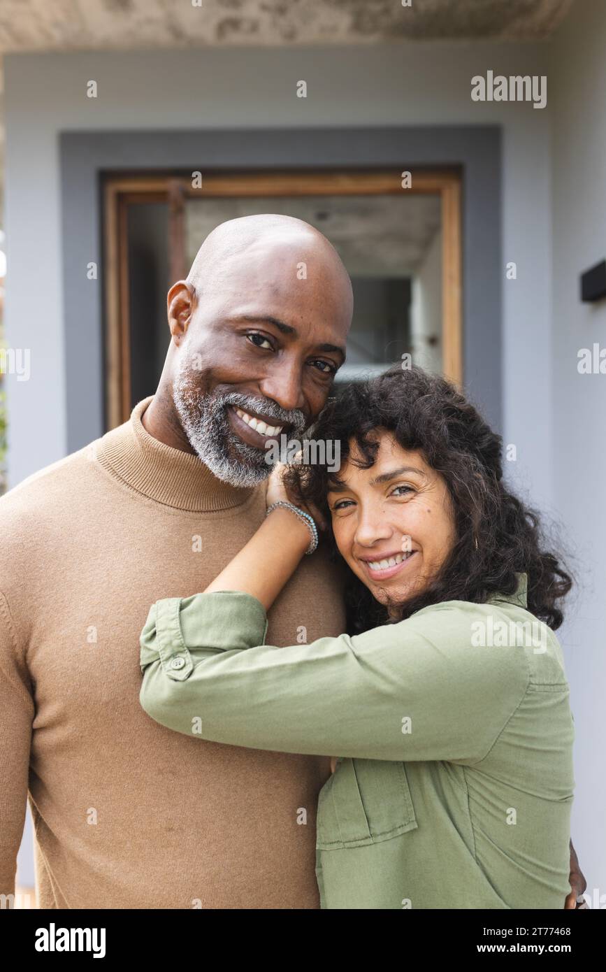 Portrait of happy mature diverse couple smiling and embracing on ...
