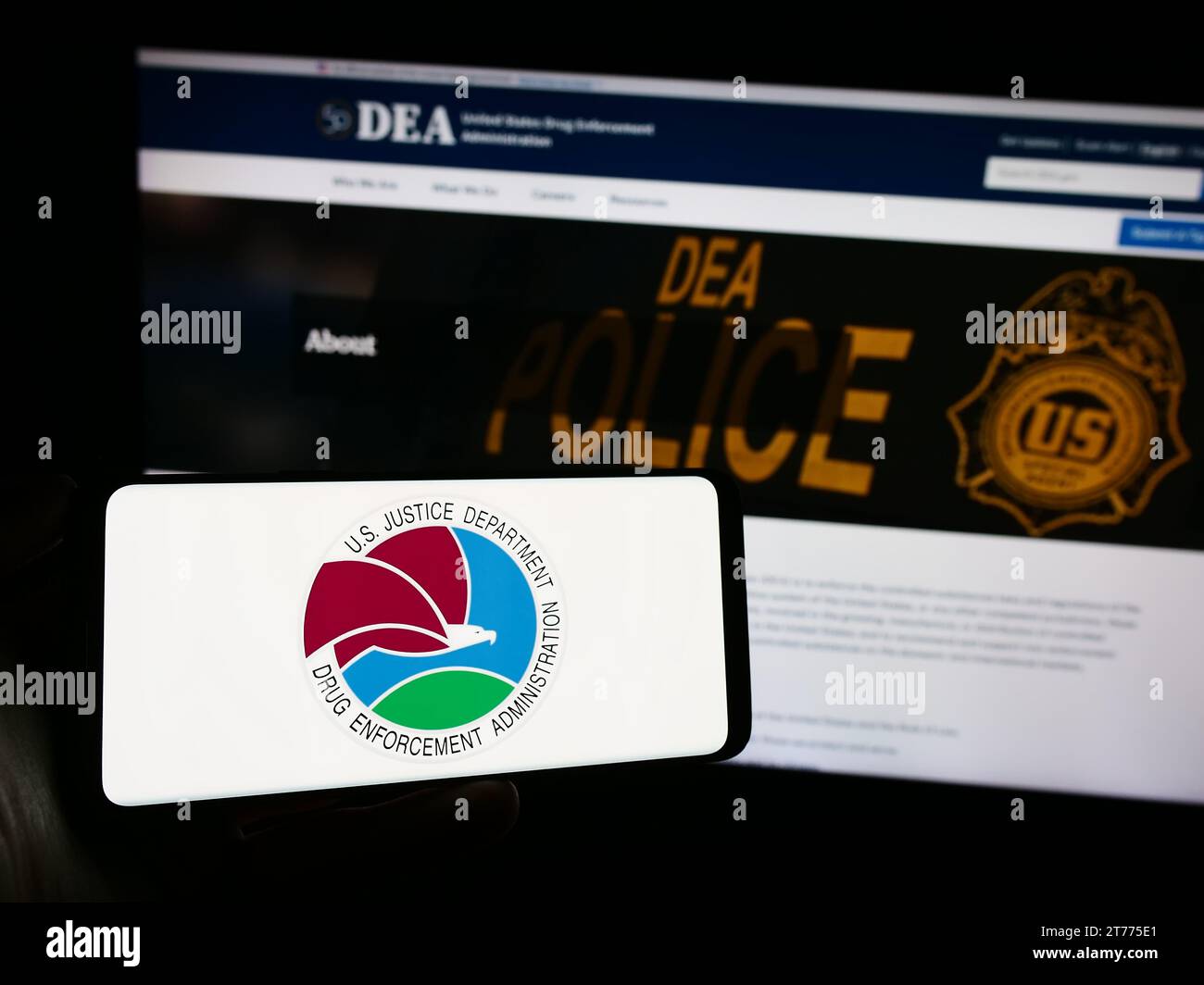 Person holding smartphone with seal of United States Drug Enforcement Administration (DEA) in front of website. Focus on phone display. Stock Photo