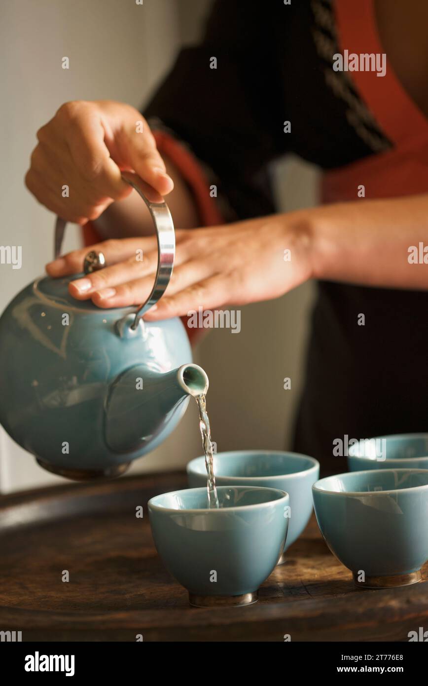 Close up of a woman hands pouring green tea Stock Photo