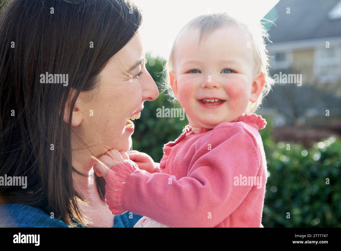 Mother Holding Baby Girl Outdoors Stock Photo