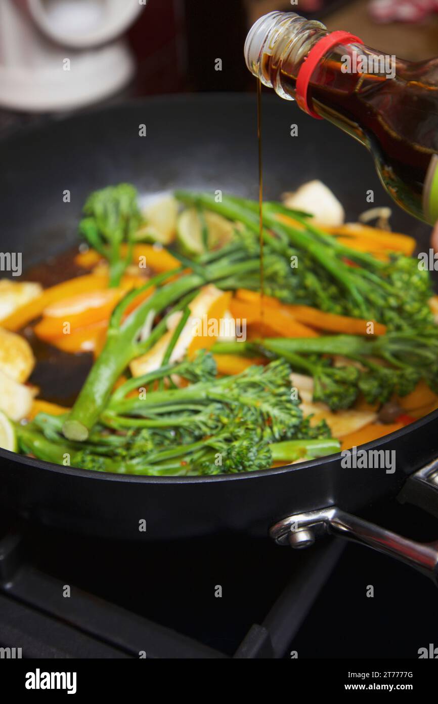 Adding Soy Sauce to Vegetable Stir Fry Stock Photo Alamy