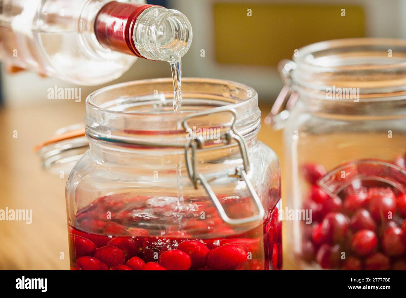 Adding Vodka to Cherries in Mason Jar Stock Photo