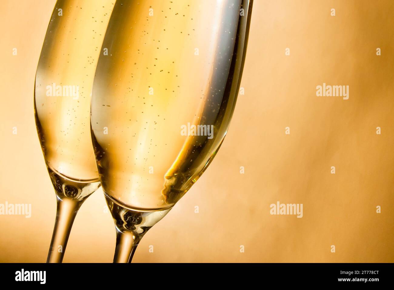 flutes of champagne with golden bubbles against golden background Stock ...