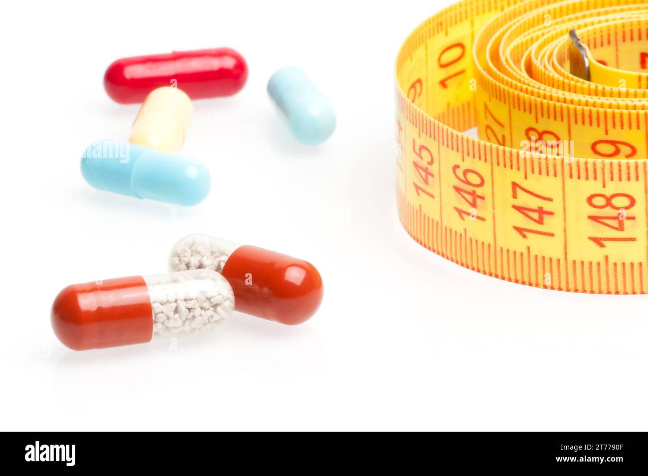 measuring tape and pills for dieting on a white background Stock Photo