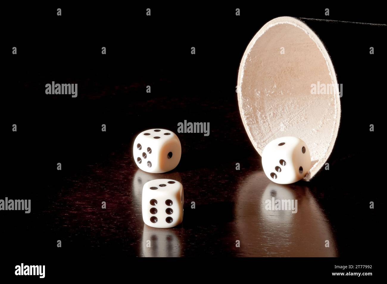 white dice near the container on old wood table Stock Photo
