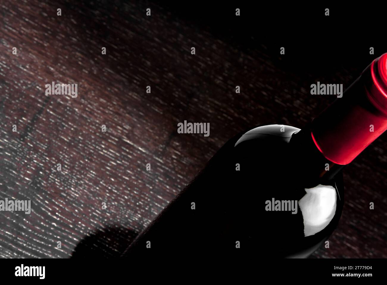 detail of a red wine bottle with space for text on old wood table Stock Photo