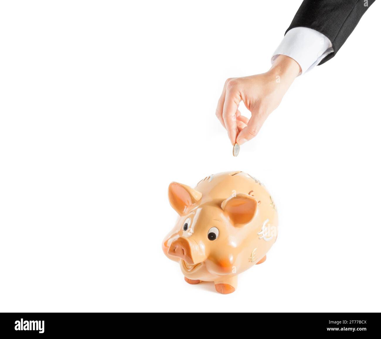 detail of a businessman hand inserting a coin into a piggy bank ...